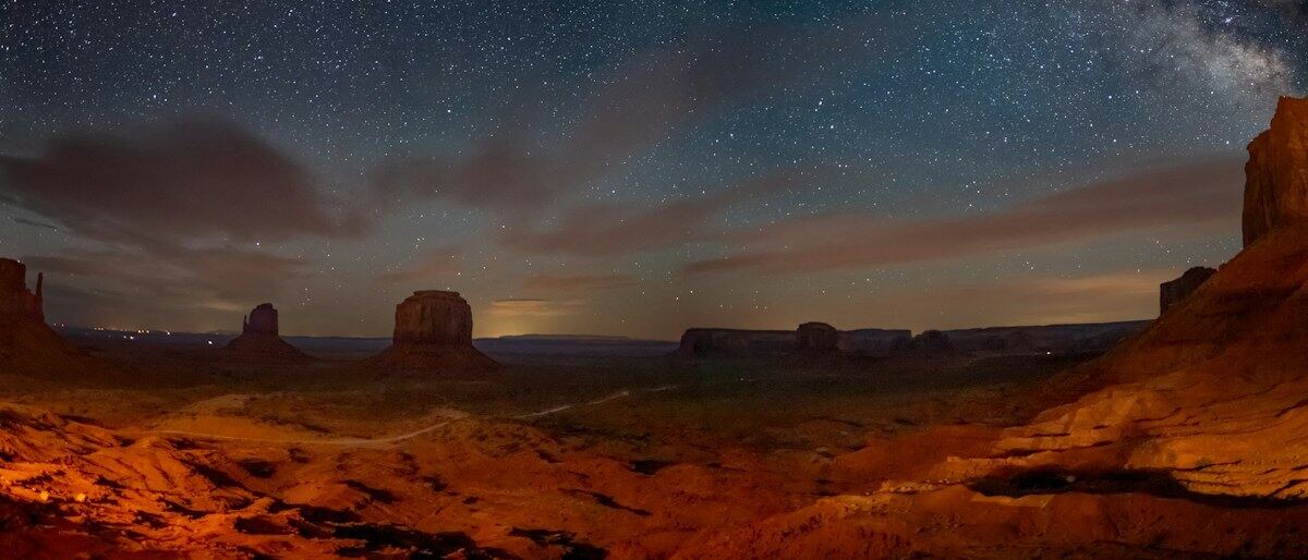 A Via Láctea sobre uma paisagem desértica à noite