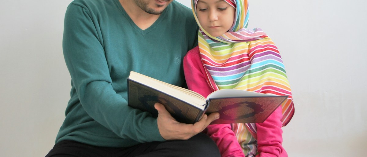 A father and daughter reading a book together