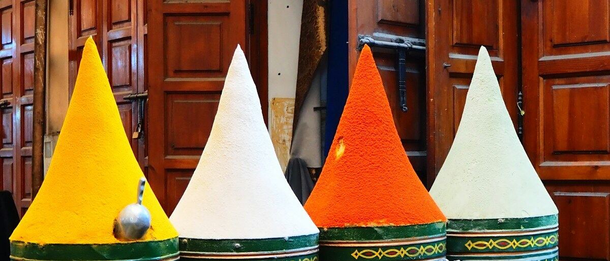 Cones de especiarias de cores vivas numa banca de mercado