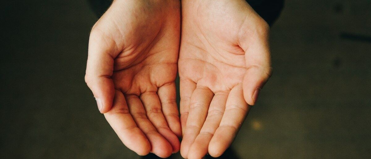 Zwei geöffnete, ausgestreckte Hände mit den Handflächen nach oben